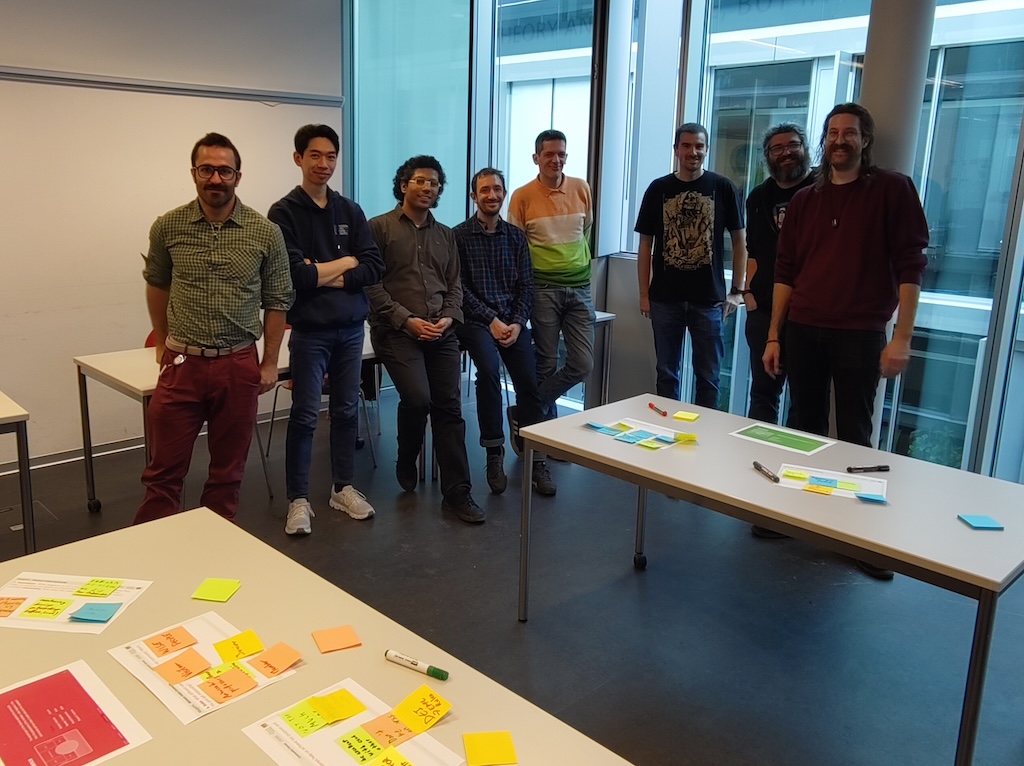 A group of RSEs posing for a photo. In the foreground some papers filled with post-its.